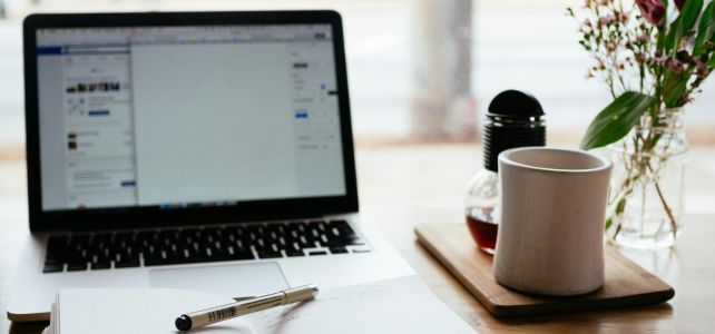 Un ordinateur, un carnet avec un stylo et une tasse de café : prêt pour un webinaire